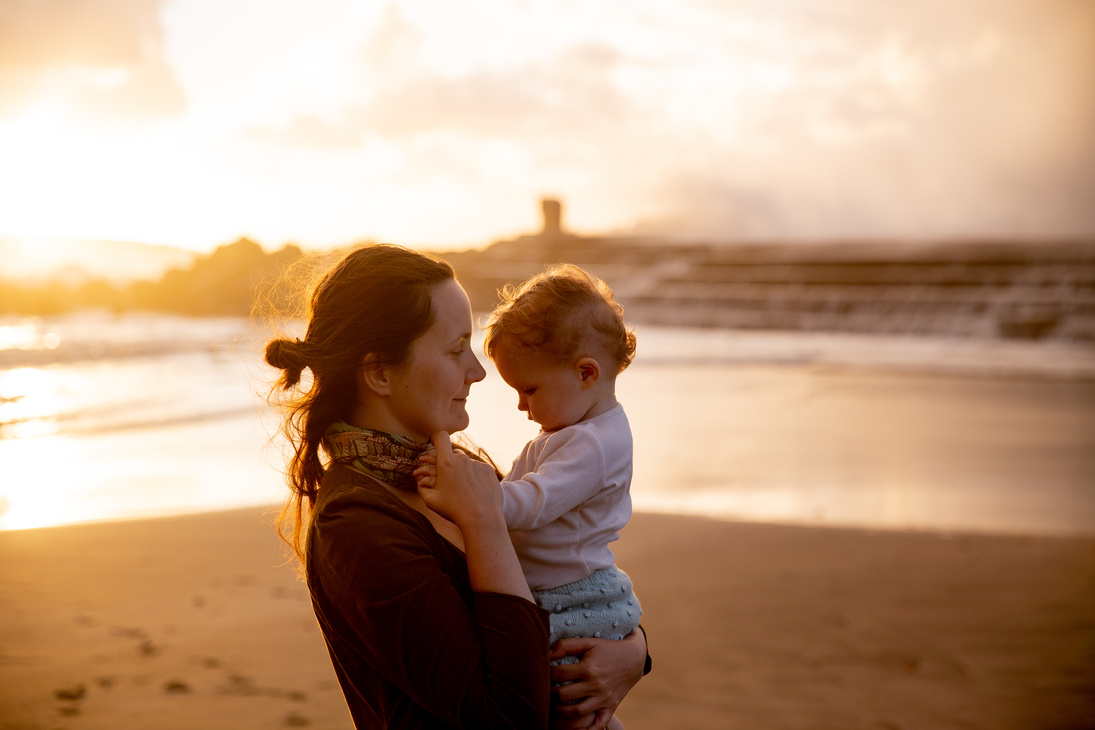 Shallow Focus Photo of Mother Carrying Her Baby